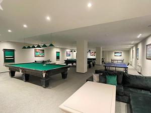 a living room with a pool table and couches at Arena Apartments & Villas Guba in Quba