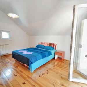 a bedroom with a bed with a blue comforter and a mirror at 3 bedrooms chalet with enclosed garden and wifi at Herceg Novi 2 km away from the slopes in Herceg-Novi