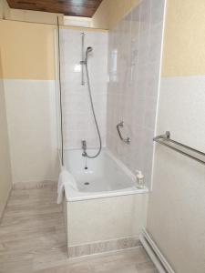 ein weißes Bad mit einer Dusche und einer Badewanne in der Unterkunft AUX GORGES DU DOURDOU in Conques-en-Rouergue + 12 Fotos