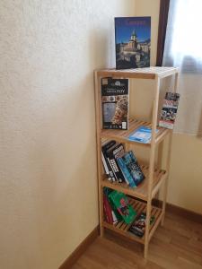 ein Bücherregal mit Büchern neben einer Wand in der Unterkunft AUX GORGES DU DOURDOU in Conques-en-Rouergue