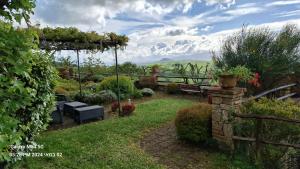 een tuin met een bank en een pergola bij Borgo Fastelli in Sarteano