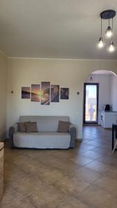 - un salon avec un canapé et des photos sur le mur dans l'établissement La terrazza, à Tarquinia