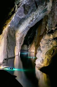 a cave with a boat in the water at night at Phong Nha Backpacker Hostel in Cừ Lạc