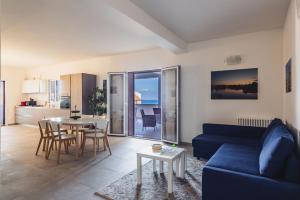 a living room with a blue couch and a table at Etna Mare Apartments by Wonderful Italy in Augusta