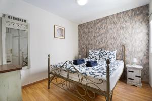 a bedroom with a bed with blue and white sheets at Nido Andrea in San Isidro