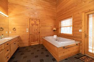 a bathroom with a tub and a sink at Swan Lodge - Walking distance to downtown Saugatuck - Modern Cabin Getaway! in Saugatuck +47 photos