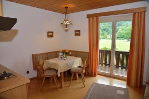 een eetkamer met een tafel en een balkon bij Ferienwohnungen Haus Monika in Aschau im Chiemgau
