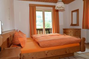 łóżko w sypialni z oknem w obiekcie Ferienwohnungen Haus Monika w mieście Aschau im Chiemgau