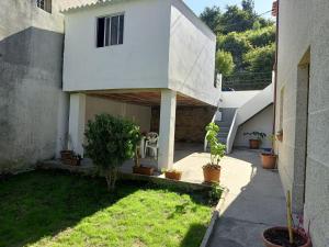 een wit huis met een binnenplaats met potplanten bij Morada Amad in Moaña