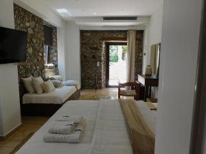 a bedroom with a bed and a living room at Olympus Stone Lodge in Litochoro