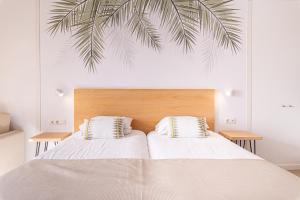 una camera da letto con un grande letto con una foglia di palma sul muro di Atlantic Holiday Hotel a Callao Salvaje