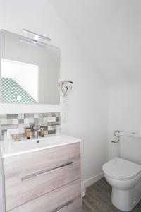 a bathroom with a toilet and a sink at Hôtel de Matignon Restaurant Le EmLo in Matignon