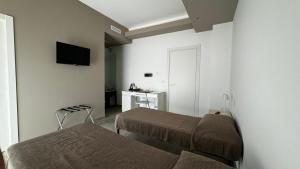 a hotel room with two beds and a desk at B&B Campo Sportivo in Taurianova