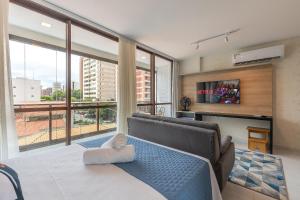 a living room with a bed and a large window at JSmart#304 - Apartamento em Fortaleza by Carpediem in Fortaleza