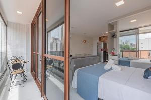een slaapkamer met een blauw bed en een balkon bij JSmart#304 - Apartamento em Fortaleza by Carpediem in Fortaleza