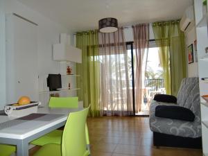 a dining room with a table and green chairs at Estudios Marco Polo V.v. in La Manga del Mar Menor