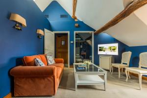 a living room with blue walls and an orange couch at Les Hauts de Loire in Onzain