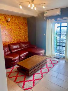 a living room with a leather couch and a coffee table at Studio lumineux in Douala