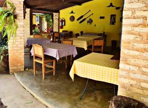 um restaurante com mesas e cadeiras e uma parede amarela em Pousada Barracuda Pipa em Pipa