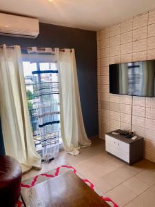 a living room with a large window and a television at Studio lumineux in Douala