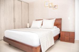 1 dormitorio con 1 cama grande con sábanas blancas en Torre Ginebra, en Medellín
