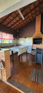 a large kitchen with a table in a room at Sitio localizado na cidade São José do Rio Preto, Espaço é ideal para Aniversários e Confraternizações. in Sao Jose do Rio Preto