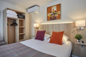 巴黎的住宿－堡格林內爾埃菲爾鐵塔酒店，卧室配有一张带两个枕头的大白色床