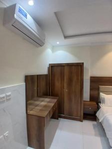 Schlafzimmer mit einem Schreibtisch und einem Bett in der Unterkunft كيان التيسير للشقق المخدومة - Kayan Al Tayseer Serviced Apartments in Quwayzah