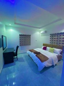 a bedroom with a large bed and a desk at lnfinity Luxury Apartment in Abuja