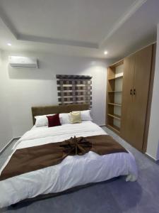 a bedroom with a large bed with a bow on it at lnfinity Luxury Apartment in Abuja