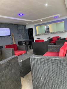 una sala de espera con sillas rojas y una pantalla de proyección en lnfinity Luxury Apartment, en Abuja