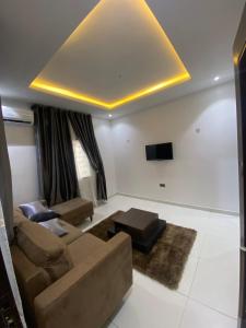 a living room with a couch and a flat screen tv at lnfinity Luxury Apartment in Abuja