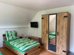a small bedroom with a bed and a mirror at Ferienwohnung Hagweg in Untermünkheim