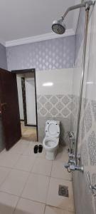 een badkamer met een toilet, een douche en een deur bij Concept Guest House in Islamabad