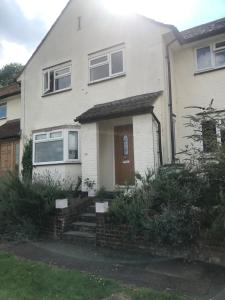 Casa blanca con puerta marrón y escaleras en En-suite with double bed on mezzanine and desk in family home en Hertford