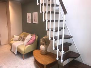 sala de estar con sofá y escalera de caracol en En-suite with double bed on mezzanine and desk in family home en Hertford