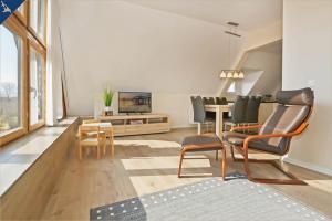 een woonkamer met een tv en een tafel en stoelen bij Apartment Atelier in Bansin