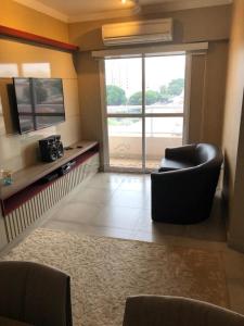 a living room with two chairs and a large window at Apartamento todo mobiliado - Completo! in Sao Jose do Rio Preto