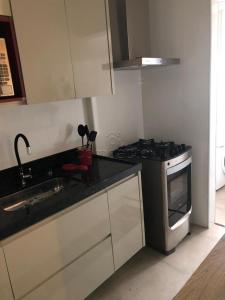 a small kitchen with a stove and a sink at Apartamento todo mobiliado - Completo! in Sao Jose do Rio Preto