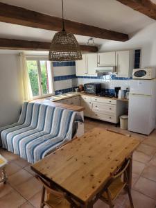 une cuisine avec une table en bois dans une pièce dans l'établissement Gîtes Les Fées du Gard - Au pied des Cévennes, à Rousson