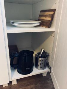 a cupboard with plates and utensils on it at FREE Apartment - Bei der Stadtmauer in Reutlingen