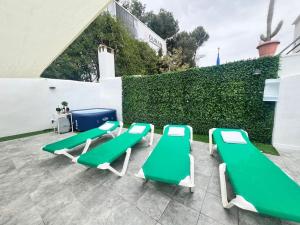 a group of green and white lounge chairs on a patio at Casona LOW COST Fan Lujo in Palma de Mallorca