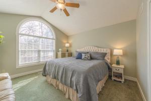 a bedroom with a bed with a ceiling fan and a window at Bed & Birdie - New Vacation Rental - Close to golf course & downtown in Saugatuck