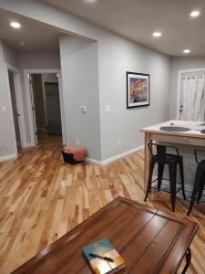 ein Wohnzimmer mit einem Tisch und Holzboden in der Unterkunft Modern, Newly-Renovated Home in the heart of LAX in La Crosse