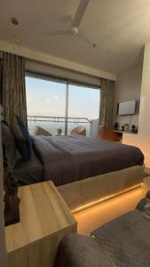 a bedroom with a large bed and a large window at Luxury Heights with City View and River View in Noida +16 photos