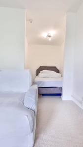 Habitación con 2 camas y sofá. en Fresh and Sparkling - Free Parking, en Crystal Palace