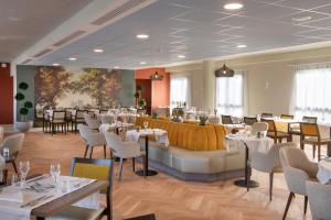 - un restaurant avec des tables et des chaises dans une salle dans l'établissement DOMITYS La Courtine, à Melun