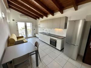 een keuken met een tafel en een koelkast bij Grazioso e panoramico appartamento in zona residenziale a Sant'Antioco C54 in SantʼAntìoco
