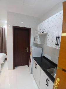 uma cozinha com um lavatório e uma porta em كيان التيسير للشقق المخدومة - Kayan Al Tayseer Serviced Apartments em Quwayzah