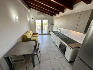 a kitchen with a table and chairs in a room at Grazioso e panoramico appartamento in zona residenziale a Sant'Antioco C54 in SantʼAntìoco +4 photos